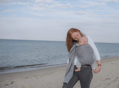 AMAZONAS chusta kółkowa do noszenia dziecka, szara, mama nosi niemowlę na plaży