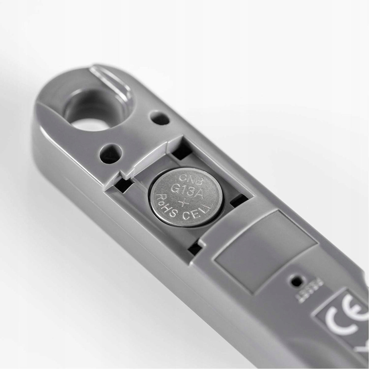 Zbliżenie otwartej komory baterii w uchwycie termometru REER FoodTemp.