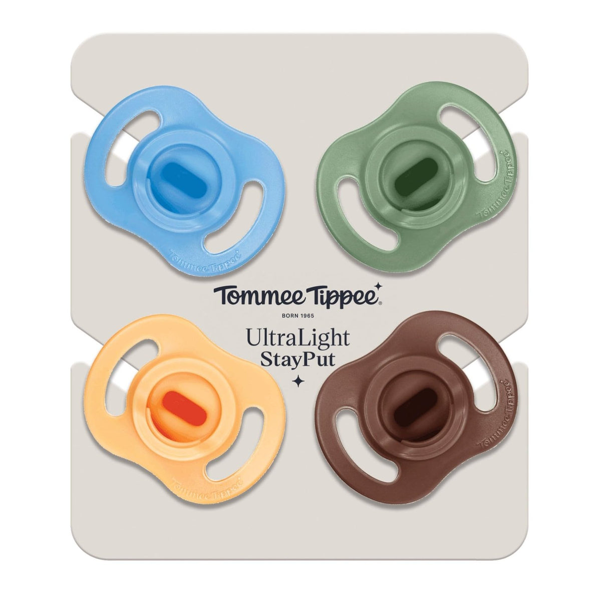 Zdjęcie poglądowe: smoczki Tommee Tippee Ultra Light StayPut na firmowym kartoniku, w kolorach niebieskim, zielonym, żółtym i brązowym.